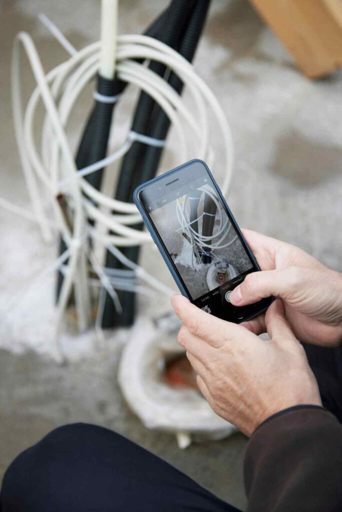 Håndværkeren dokumenterer sit arbejde med Ordrestyring via appen på sin mobiltelefon.